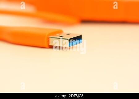 Orange hard drive for information storage and USB close-up port Stock Photo