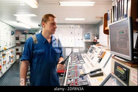 Marine Engineer working on radio communication at Engine Control room ECR Stock Photo
