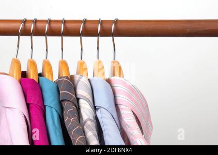 Different women's office classic shirts hang on a hanger for storing clothes. The choice of style of fashionable clothes Stock Photo