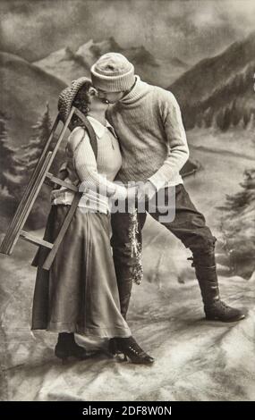 Young couple in love with sledge. Vintage picture with original film grain and blur Stock Photo