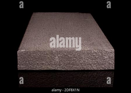 Block of thermal insulation with graphite polystyrene for thermal insulation of house walls isolated on the black background Stock Photo