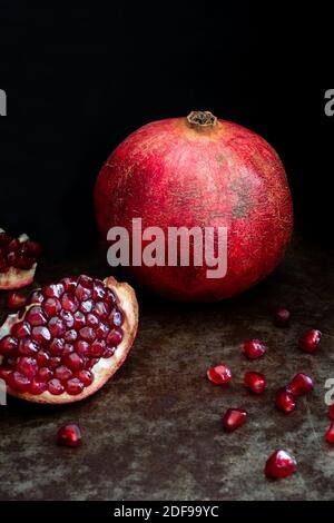 Pomegranate fruit whole and open on a black background Stock Photo