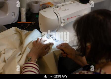Volunteers, wearing home made face mask protection against the coronavirus, of the Simplon.co fab lab makes medical blouse by hand and sewing machines for the hospitals in Paris and the Region ile de France. Paris, April 27 2020. Photo by Raphael Lafargue/ABACAPRESS.COM Stock Photo
