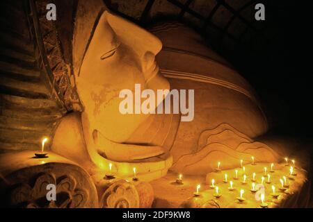 Candle offerings to 11th century reclining BUDDHA at SHINBINTHAHLYAUNG TEMPLE - BAGAN, MYANMAR Stock Photo