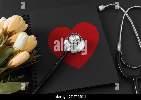 Stethoscope on notebook with red heart shape. Stock Photo