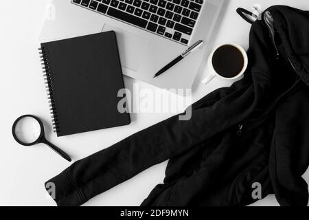 Notebook with copy space, sweater and laptop on white office table. Stock Photo