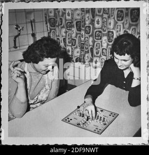 Historical Photo:  Two women playing Mensch aergere dich nicht, a parlor game 1968, in the kitchen. Reproduction in Marktoberdorf, Germany, October 26, 2020.  © Peter Schatz / Alamy Stock Photos Stock Photo