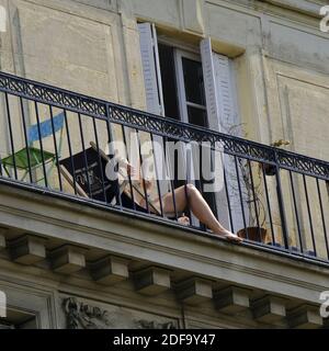 A confined Parisian enjoy sunny spring weather on the balcony during lockdown imposed to slow the spreading of the coronavirus disease (COVID-19) in Paris. after the announcement by French President Emmanuel Macron of the strict home confinement rules of the French due to an outbreak of coronavirus pandemic (COVID-19) on March 18, 2020 in Paris, France. the French will have to stay at home, France has closed down all schools, theatres, cinemas and a range of shops, with only those selling food and other essential items allowed to remain open. under penalty of sanctions, prohibiting all but ess Stock Photo