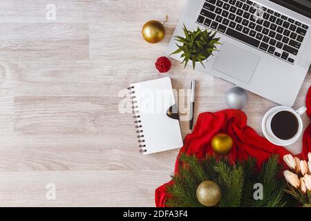 Laptop and notepad with ornaments balls on wood table. Office table on Christmas. Stock Photo