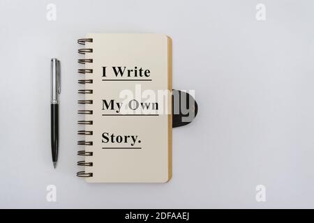 Overhead View of Notebook with Motivational Quote and Pen on White Background Stock Photo