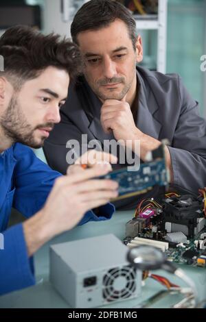 two handsome engineers working on electronics components Stock Photo