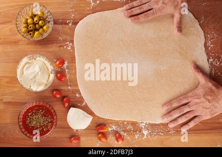 Making italian pizza step by step with ingredients for hand made pizza: ready rolled out dough Stock Photo