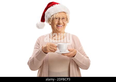 Cheerful elderly woman holding a cup and wearing a christmas santa hat isolated on white background Stock Photo