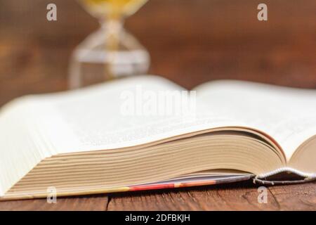 A large hardcover book lies open on an old wooden background.Close up. Stock Photo