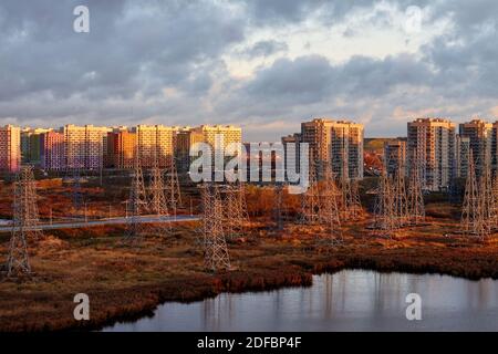 Electric towers with residential buildings on background Stock Photo