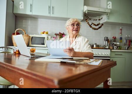Nice old woman using modern laptop at home Stock Photo