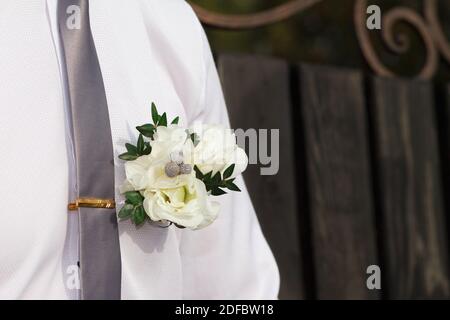 Beautiful wedding boutonniere of rose on a on a white shirt at the groom's wedding day Stock Photo