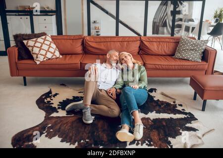 Relaxed couple sitting on the floor and resting Stock Photo