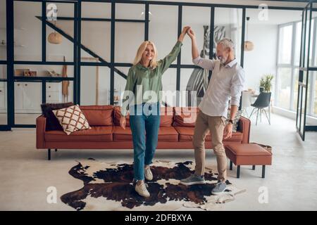 Man and woman dancing in the room and feeling good Stock Photo