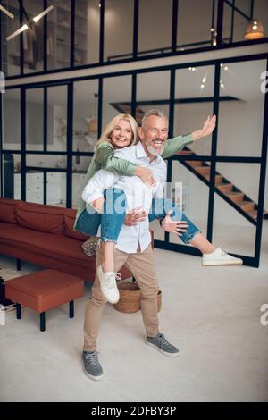 Man holding his wife on his back and both feeling awesome Stock Photo