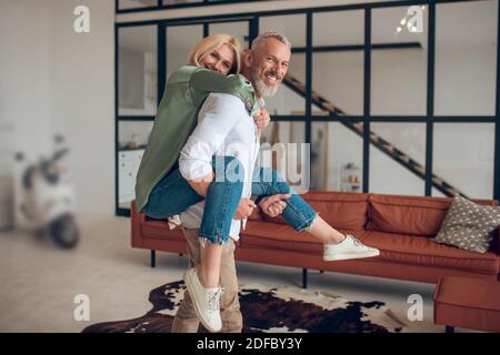 Man holding his wife on his back and both feeling wonderful Stock Photo