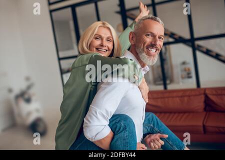 Man holding his wife on his back and both feeling awesome Stock Photo