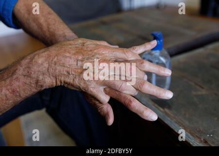 Close up view of senior caucasian man using hand sanitizer at home Stock Photo