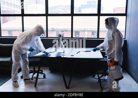 Health workers in protective clothing disinfecting creative office Stock Photo