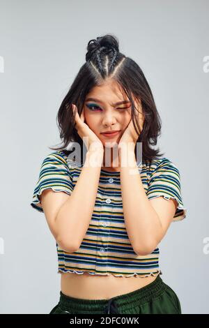 Cute young female with delicate features blinking her eyes with pleasure having happy expression. Stock Photo