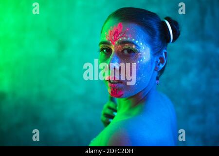 Beautiful woman with body art glowing in ultraviolet light. Ethnic, esoteric and fantasy concept. Portrait of beautiful woman painted in fluorescent p