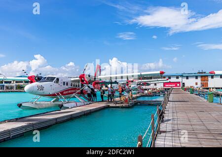 MALE, MALDIVES - Jan 23, 2017: People are boarding into docked Seaplane at Maldives airport with a beautiful sky background. Stock Photo