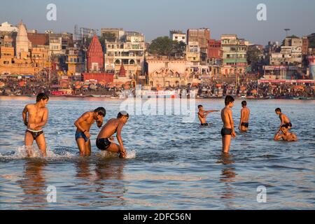 India, young men play in the holy water of the Ganges in Varanasi Stock Photo