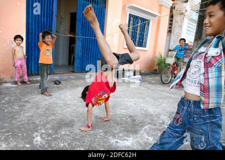 Cambodia, children bungee jumping in a street in Kampot Stock Photo