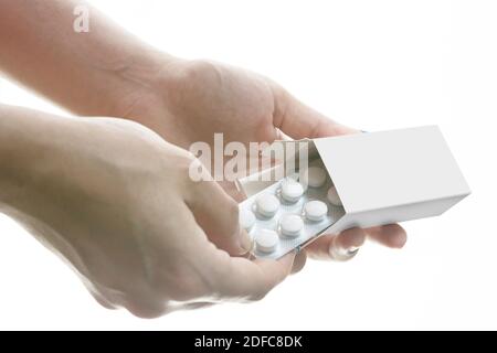 Taking out tablets from the pillbox by hands isolated on white background, editable mock-up series template ready for your design, box faces selection Stock Photo