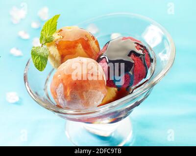 Cup of ice cream balls in three flavors coated with chocolate Stock Photo