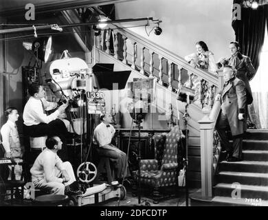 Cinematographer WILLIAM H. DANIELS Director SIDNEY FRANKLIN and Movie Crew with NORMA SHEARER FREDRIC MARCH and CHARLES LAUGHTON on set candid during filming of THE BARRETTS OF WIMPOLE STREET 1934 director SIDNEY FRANKLIN play Rudolph Besier Metro Goldwyn Mayer Stock Photo