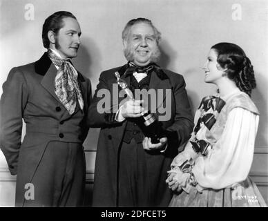 FREDRIC MARCH CHARLES LAUGHTON holding his Oscar / Academy Award for Best Actor of 1933 and NORMA SHEARER on set candid during filming of THE BARRETTS OF WIMPOLE STREET 1934 director SIDNEY FRANKLIN play Rudolph Besier Metro Goldwyn Mayer Stock Photo