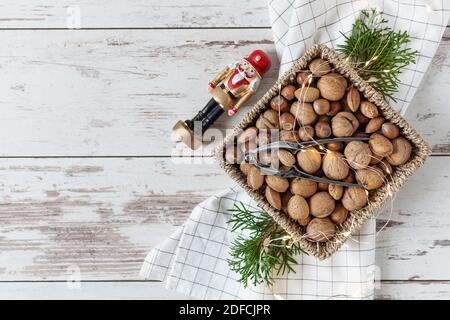 Variety of shelled nuts and nutcracker on wooden background top view. Creative gift box with many nuts for holiday. Stock Photo