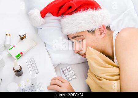 Sick Man in Santa Hat sleep in the Bed Stock Photo