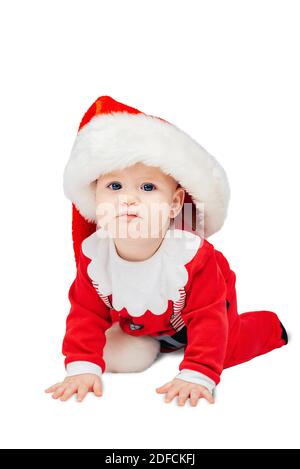 Adorable baby boy in Santa Claus hat costume on floor. Little child isolated on white background with clipping path. Happy Holidays, New year and Chri Stock Photo