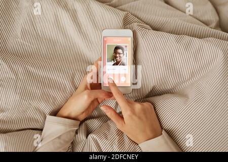 Close-up of woman looking at photo of man on her mobile phone she using online dating service Stock Photo