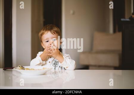 Cute little boy, eating spaghetti at home for lunchtime Stock Photo