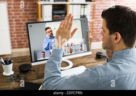 Raising Hand To Ask Questions In Training Video Conference Stock Photo