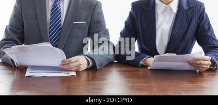 Two businessmen in elegant suits at a business meeting discussing documents in the office Stock Photo