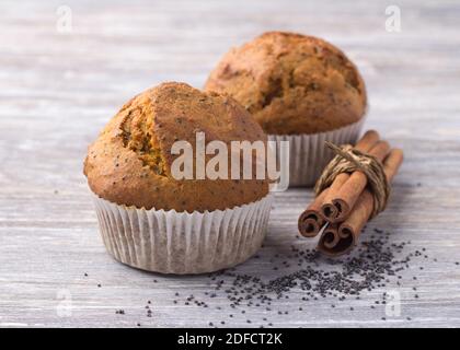 Pumpkin muffins with poppy seeds and cinnamon on a wooden table. Delicious homemade food Stock Photo