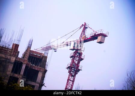 Cranes on a construction site. Building construction site with tower cranes against blue sky. Stock Photo