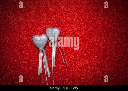 red shiny background with silver hearts, love, Valentine's Day, texture abstract background, romantic picture, suitable for advertisement, insert text Stock Photo