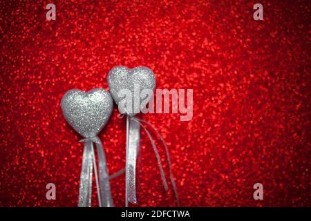 red shiny background with silver hearts, love, Valentine's Day, texture abstract background, romantic picture, suitable for advertisement, insert text Stock Photo