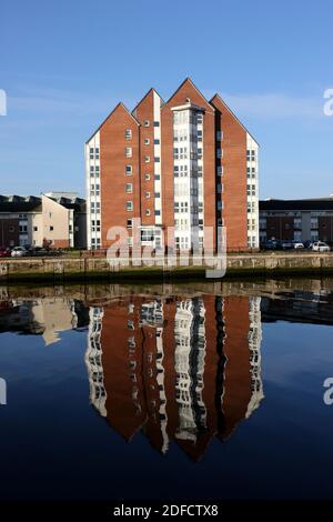 Ayr, Ayrshire, Scotland  Reflection of high rise flats in the River Ayr at mouth of the harbour Stock Photo