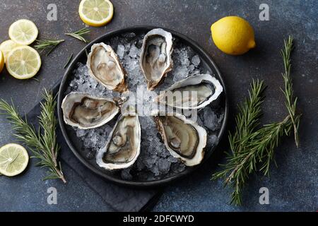 Fresh opened oysters on ice, textured background Stock Photo